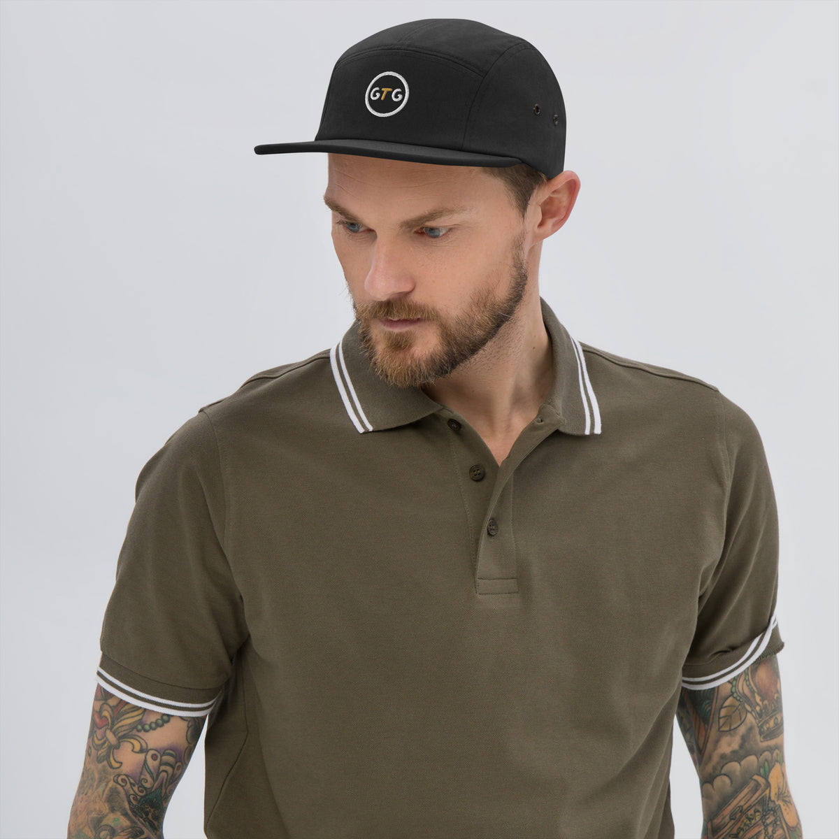 Model wearing the GTG 5-Panel Camp Cap in Black with embroidered GTG badge