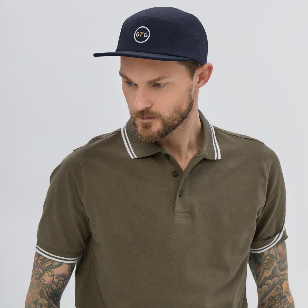 Model wearing the GTG 5-Panel Camp Cap in Navy with embroidered GTG badge