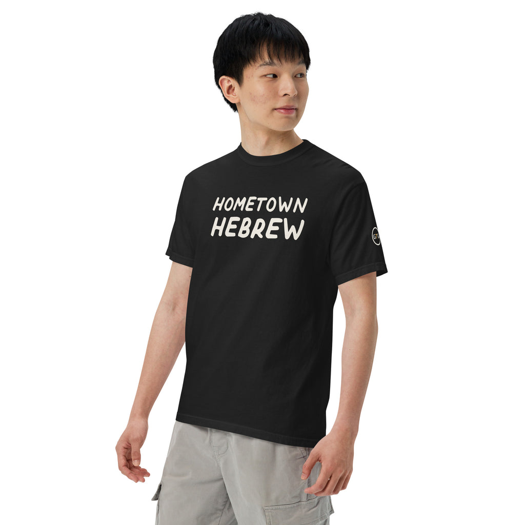 Model wearing the Good Thank God Hometown Hebrew T-shirt in Black, left front view showing the GTG sleeve badge