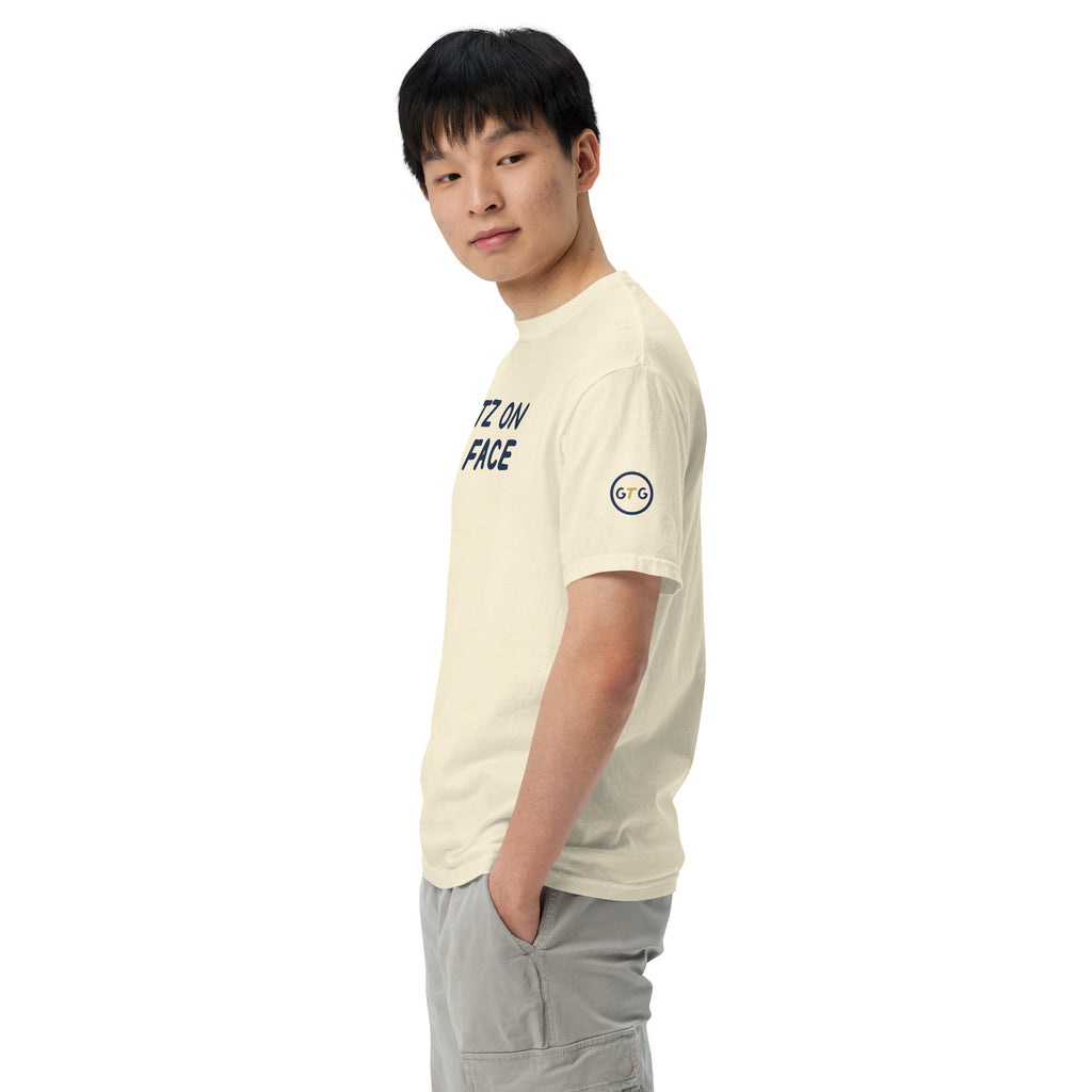 Model wearing the Good Thank God Shmutz on Your Face T-shirt in Ivory, left side view showing the GTG sleeve badge